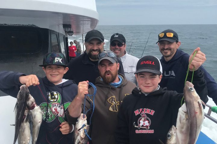 a group of people standing in front of a fish