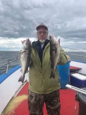 a man holding a fish on a boat