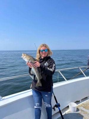 a woman standing next to a body of water
