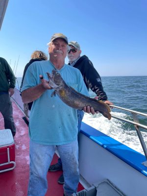 a man holding a fish on a boat