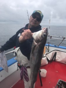 a person holding a fish on a boat in the water