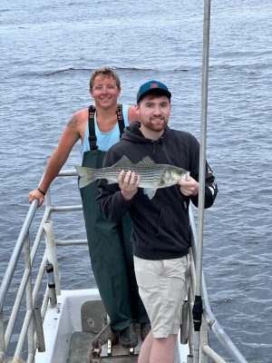 a man and a woman standing next to a body of water