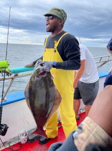 a man holding a fish on a boat