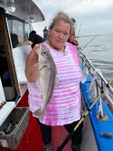 a person holding a fish on a boat