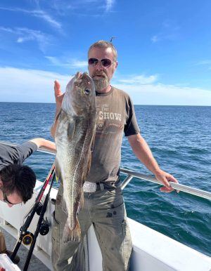 a man holding a fish in the water