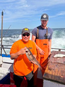 Joel Lamangan holding a fish on a boat in the water