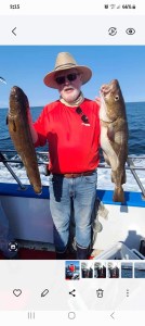 a man holding a fish on a boat