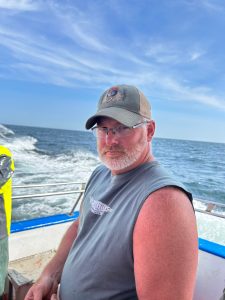 a man standing next to a body of water