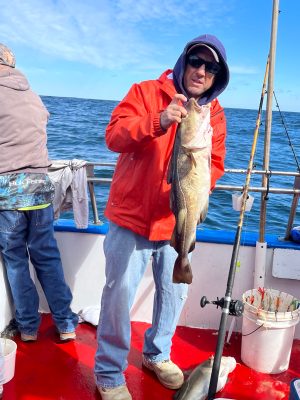 a person holding a fish on a boat in a body of water