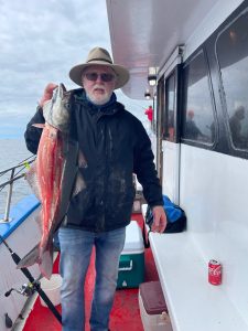 a man holding a fish posing for the camera