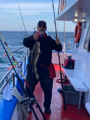 a person holding a fish on a boat in the water