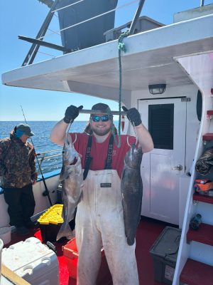 a person holding a fish on a boat
