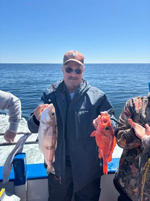 a man holding a fish on a boat in a body of water