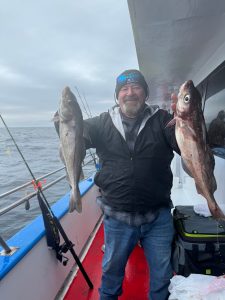 a man holding a fish on a boat