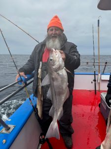 a man holding a fish on a boat