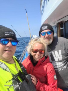 a person wearing sunglasses holding a fish