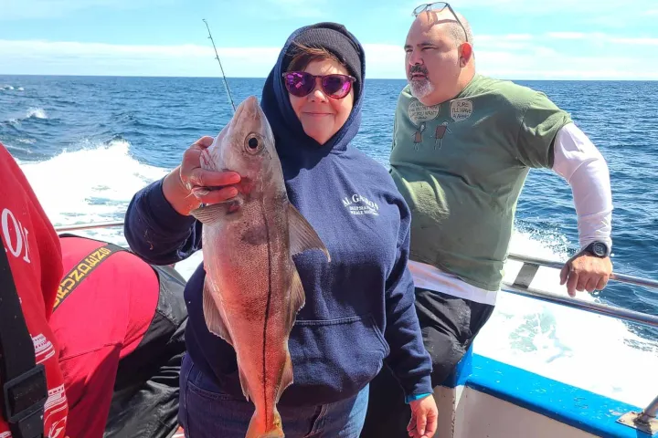 a group of people standing next to a body of water
