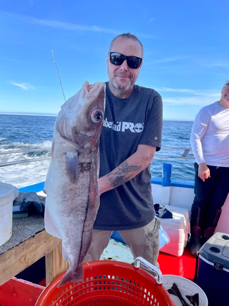 a man holding a fish in the water