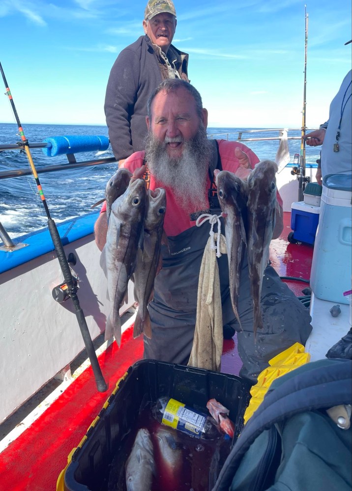 a man holding a fish on a boat