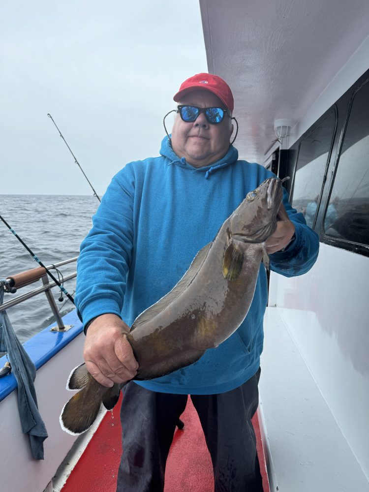 a man holding a fish on a boat