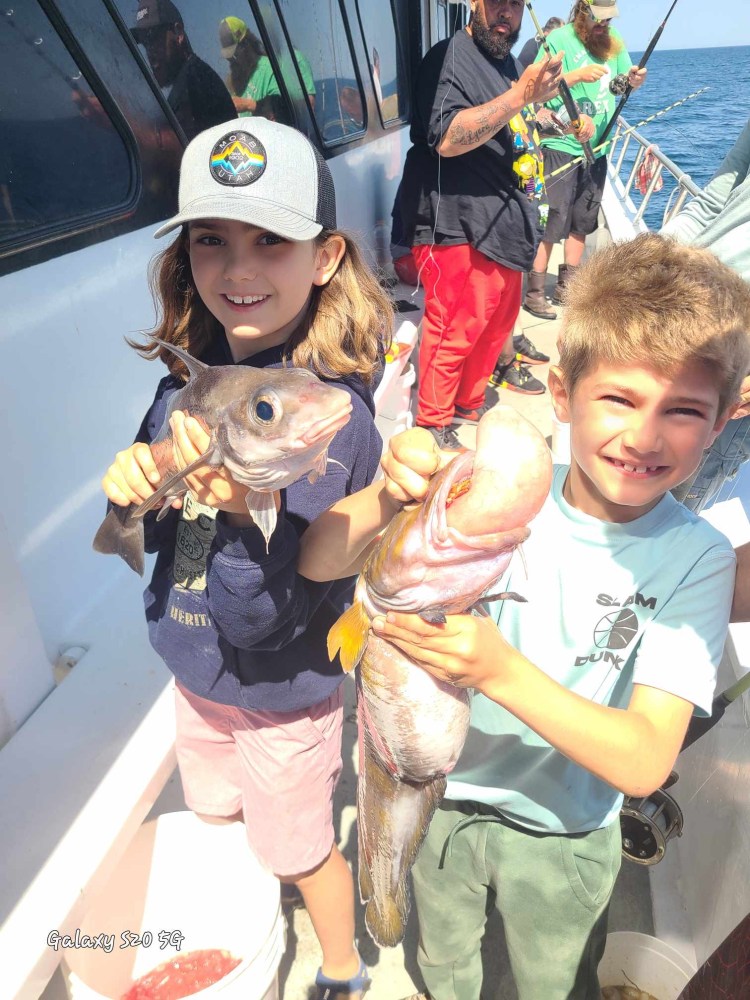 a young boy holding a fish