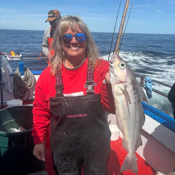 a person holding a fish on a boat