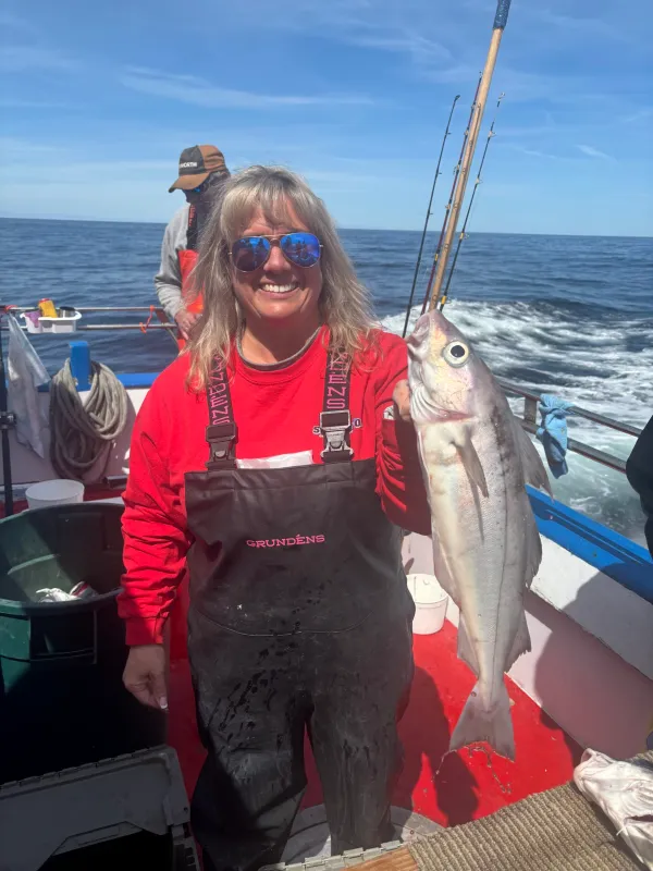 a person holding a fish on a boat