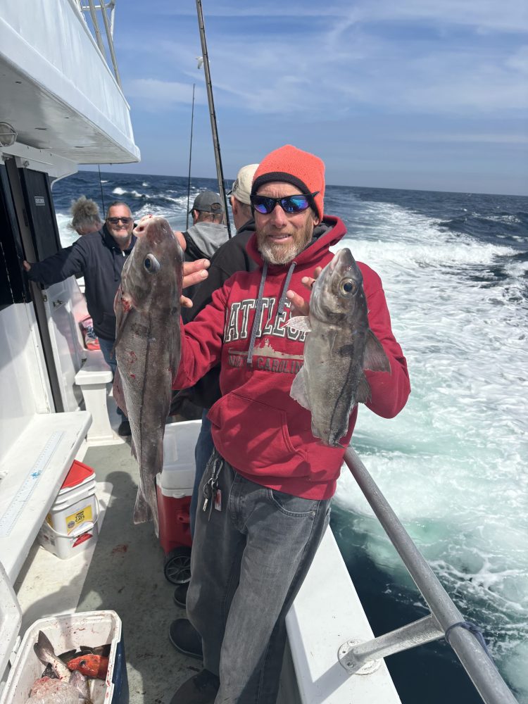 a person holding a fish on a boat posing for the camera