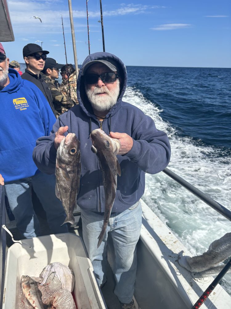 a person holding a fish on a boat in the water