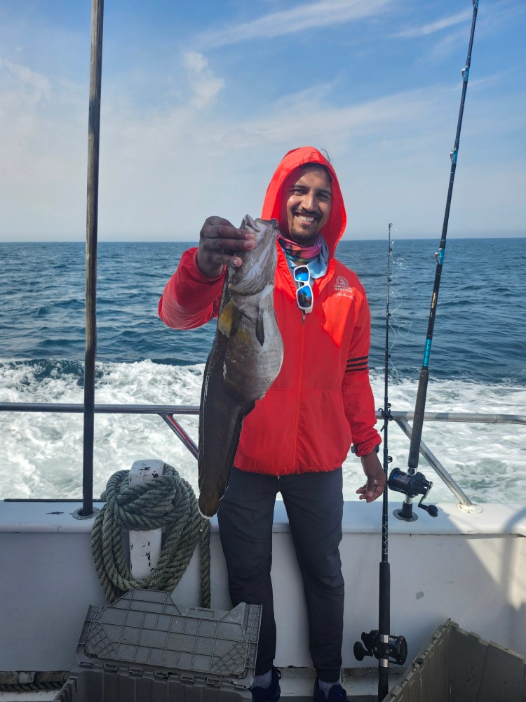 a person holding a fish on a boat in the water