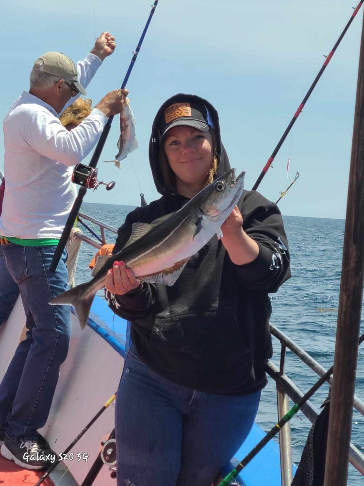 a person holding a fish on a boat