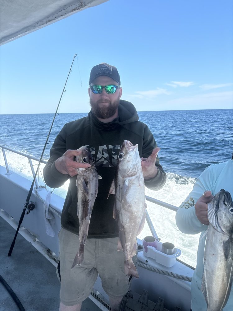 a man holding a fish on a boat in the water