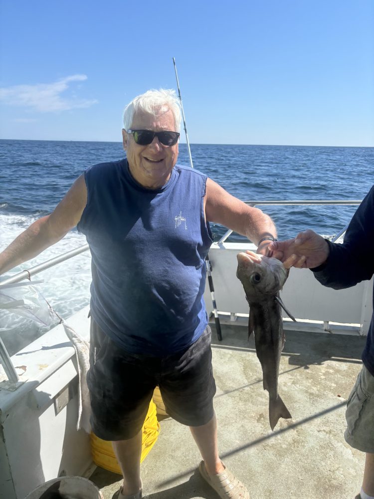 a man holding a fish in the water