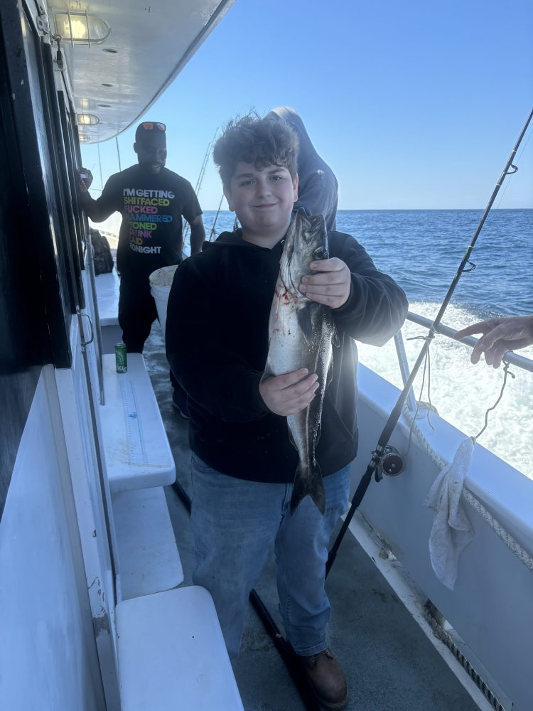 a person holding a fish on a boat in the water