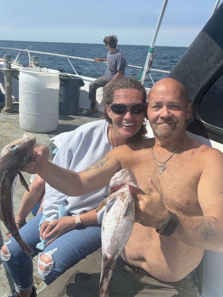 a man holding a fish on a boat