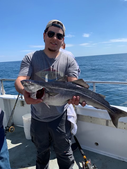 a man holding a fish on a boat