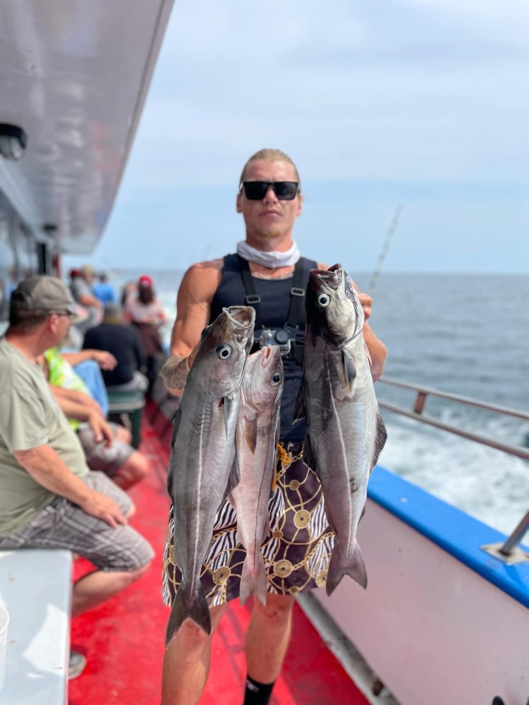 a person holding a fish on a boat