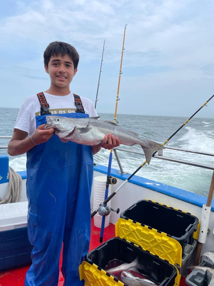 Bebeto holding a fish on a boat