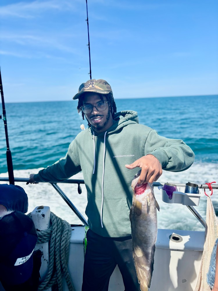 a person holding a fish on a boat in a body of water