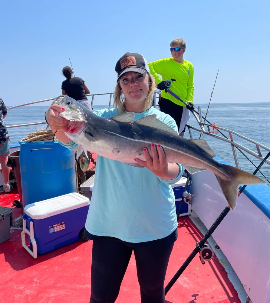 a person holding a fish on a boat