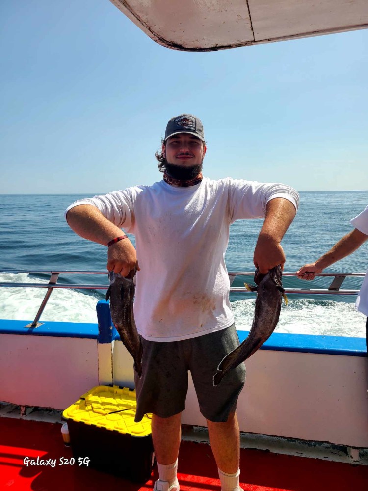 a man standing next to a body of water