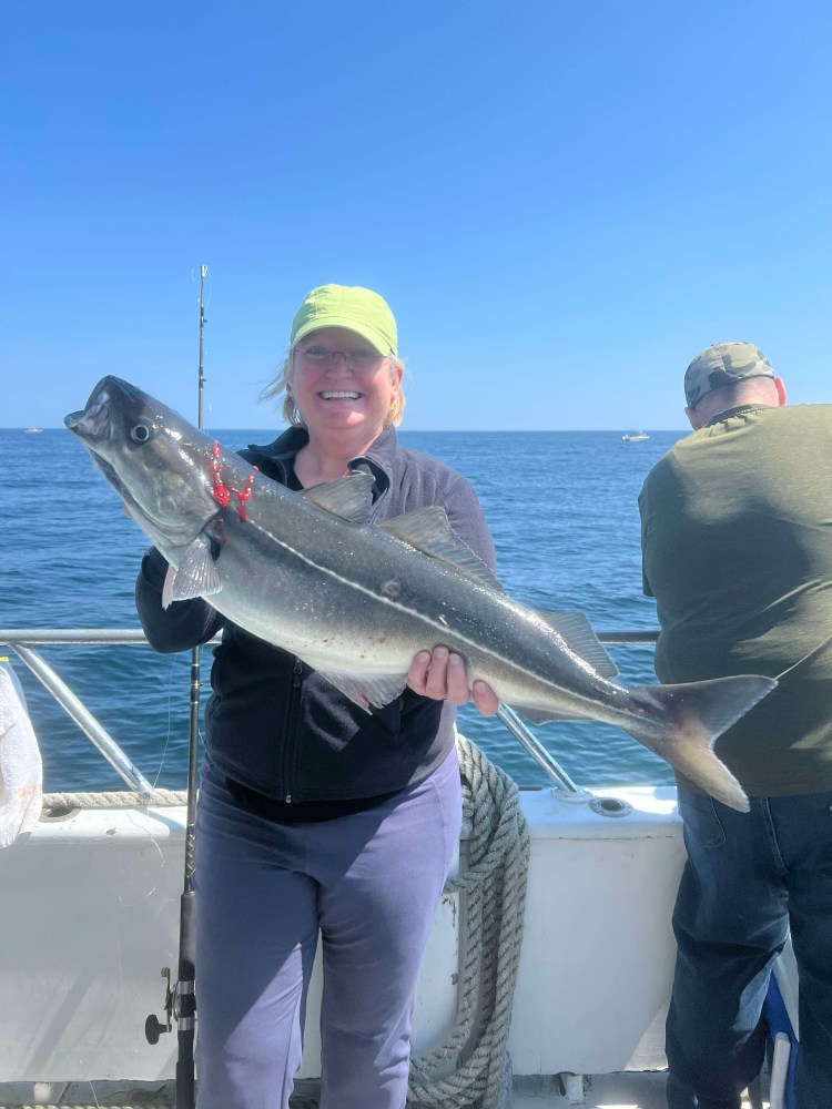 a person holding a fish on a boat in the water