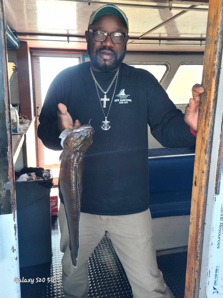 a man holding a fish posing for the camera