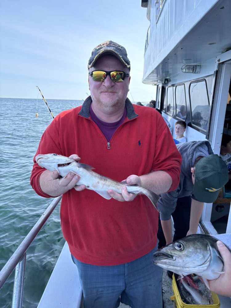 a person holding a fish on a boat