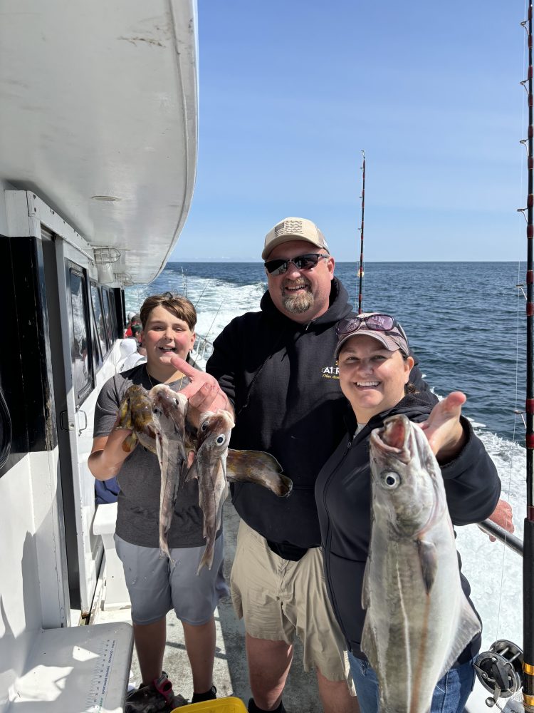 a group of people standing next to a person holding a fish