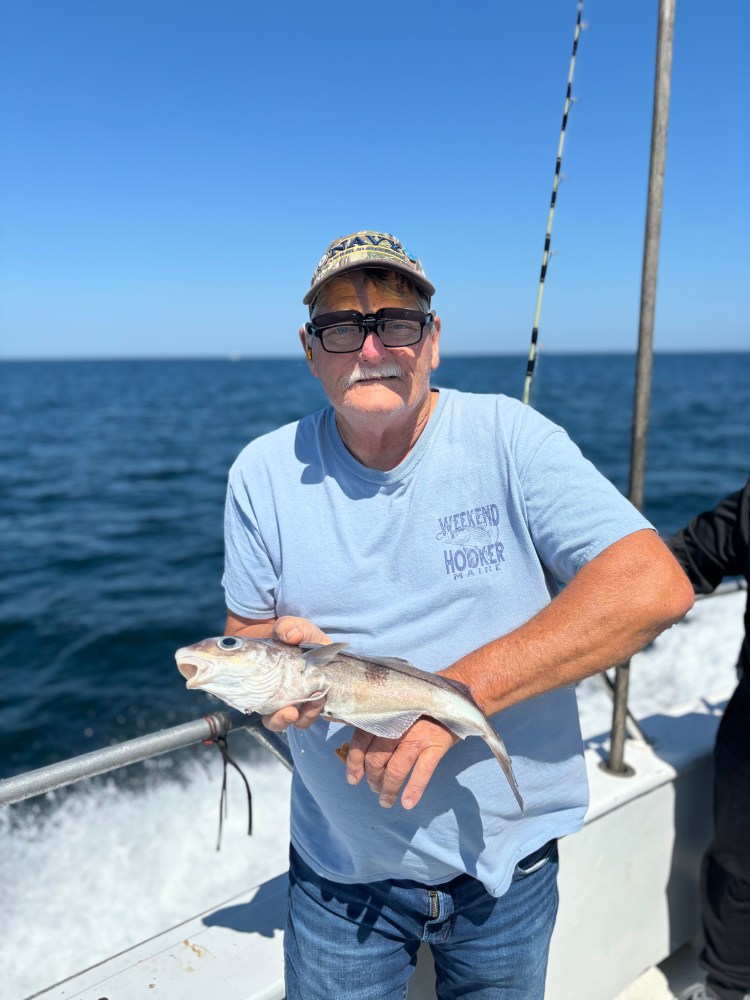 a man holding a fish in the water