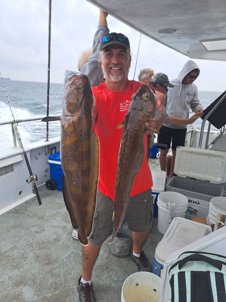 a man holding a fish on a boat