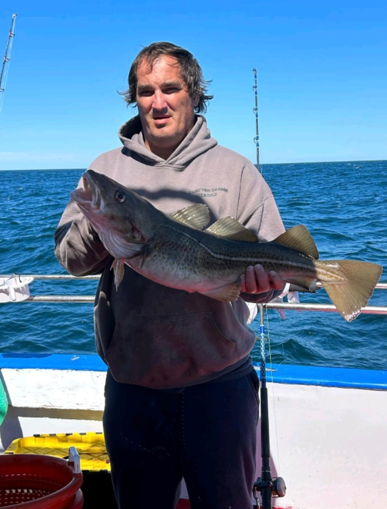 a man holding a fish in the water