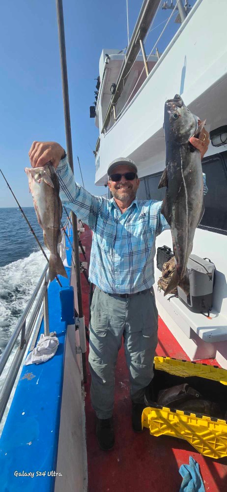 a man holding a fish on a boat