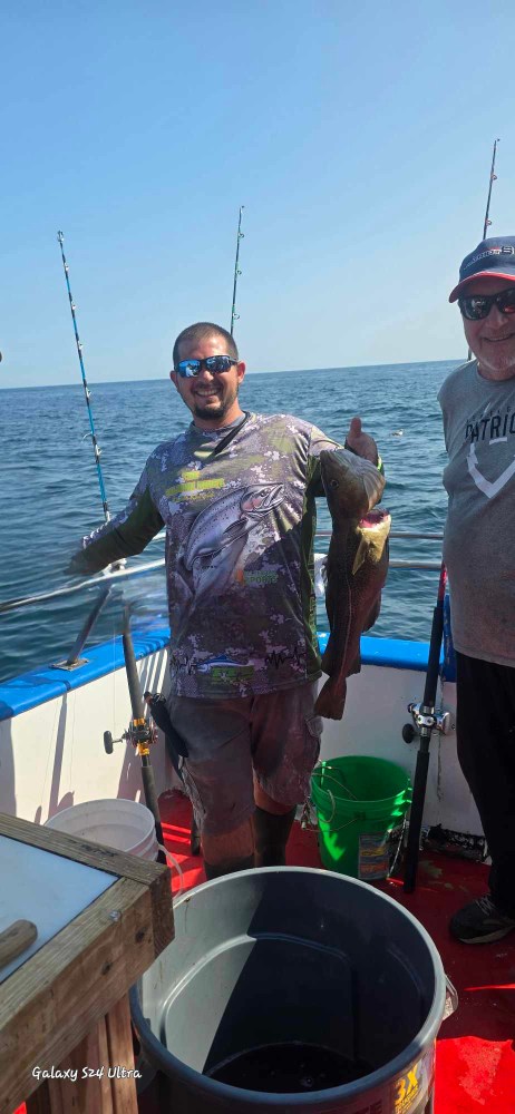 a person holding a fish on a boat in the water